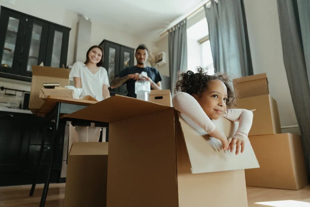 family in kitchen moving boxes and child